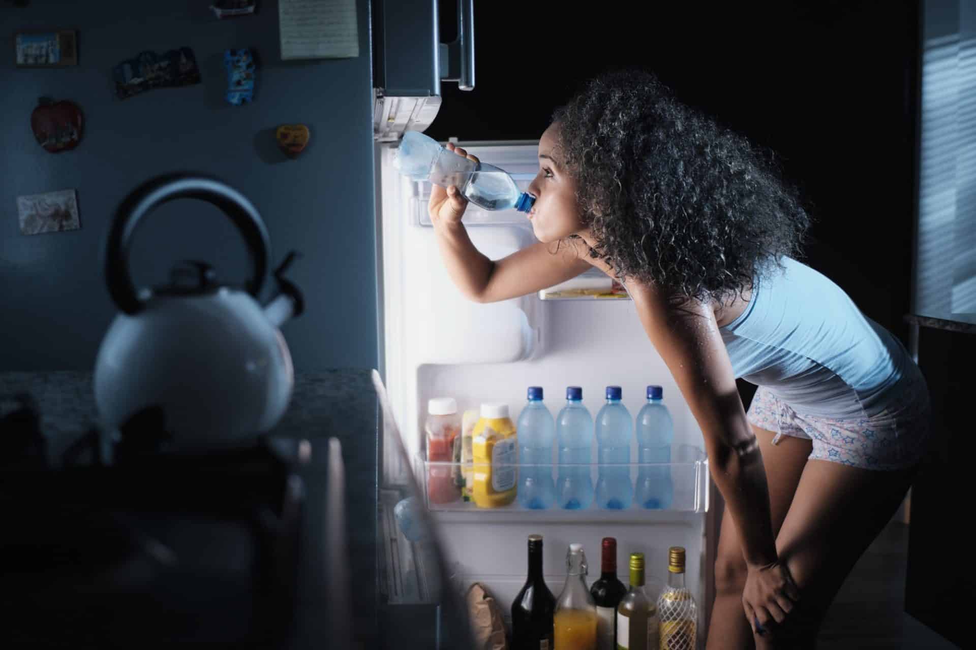 Black Woman Sweating And Drinking Water At Night