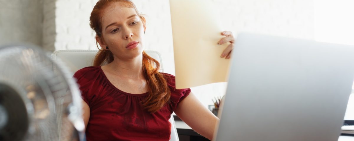 Businesswoman Sweating At Work With Broken Conditioner