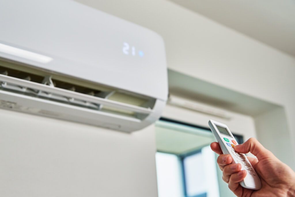 a person turns on thier newly installed mini split ac system installed by Rainbow Lakes AC
